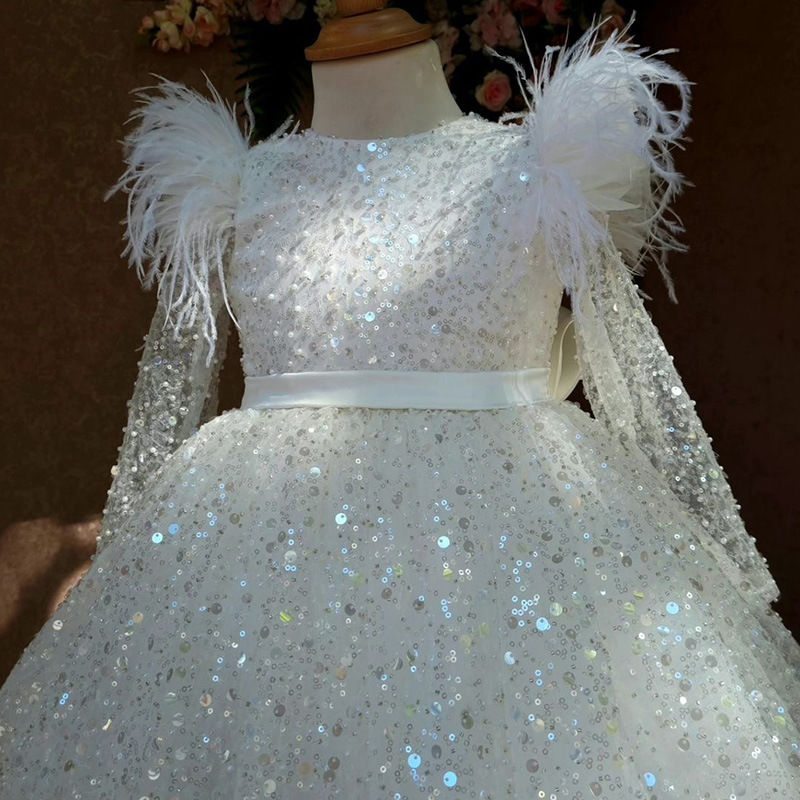 Robe blanche à paillettes et manches plumes